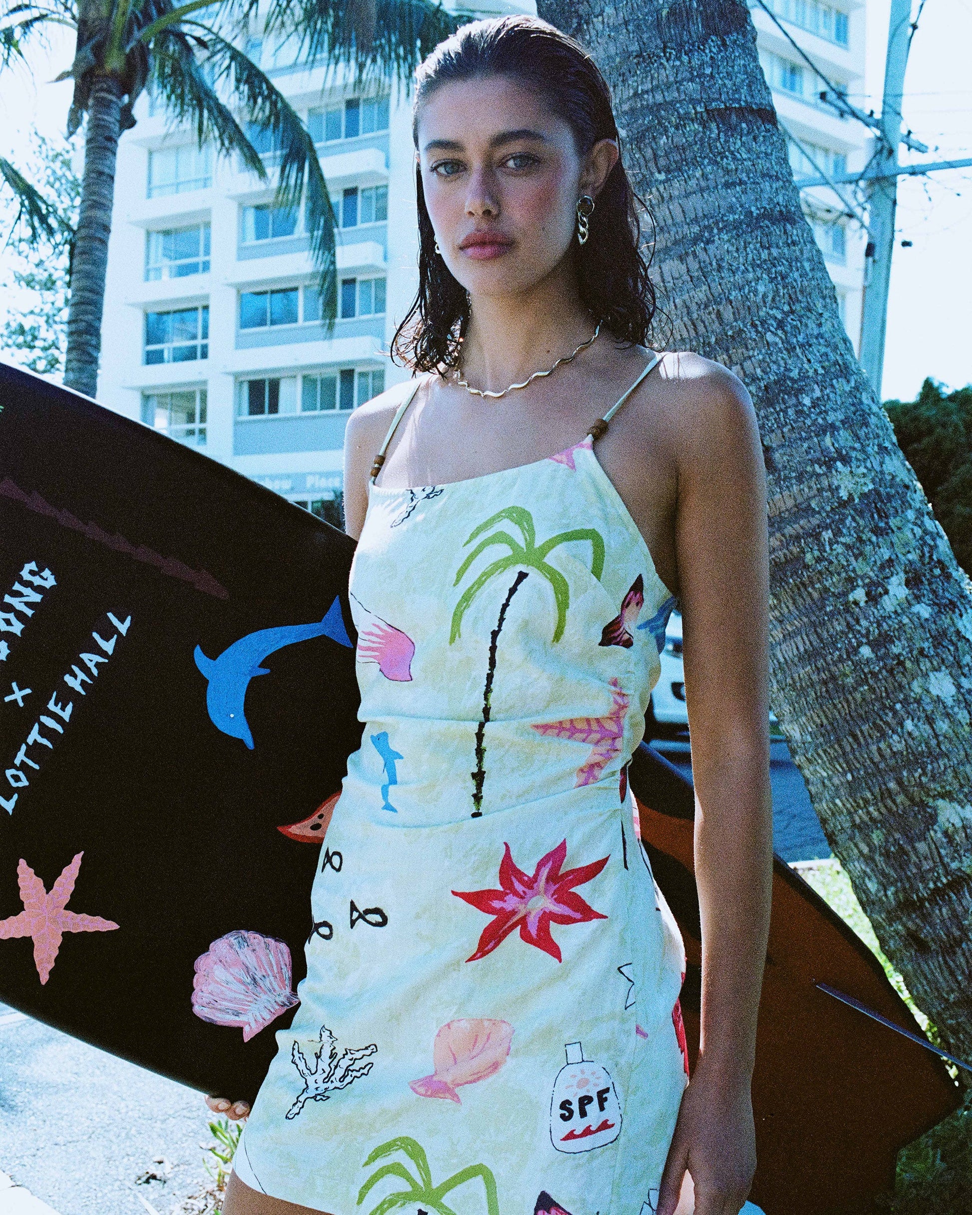 Sleeveless woven dress in pale yellow with colorful marine and tropical print, adjustable straps, fitted waist.