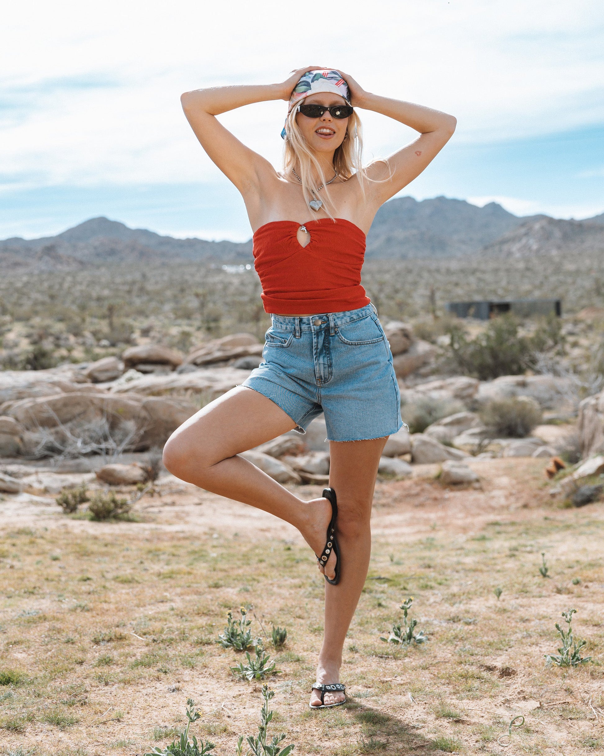 Faded indigo denim cut-off shorts with frayed edges and button-fly closure.