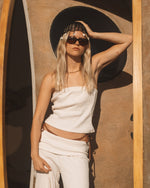 White ribbed tube top with strapless neckline and fitted silhouette.