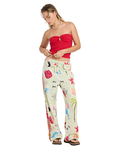 Woman wearing a true red strapless tube top with a cutout detail and cream pants with colorful floral print.
