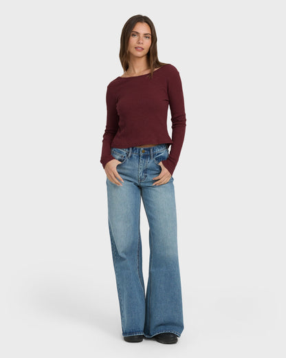 Burgundy ribbed long sleeve knit top with crew neckline, styled with light blue wide-leg jeans.