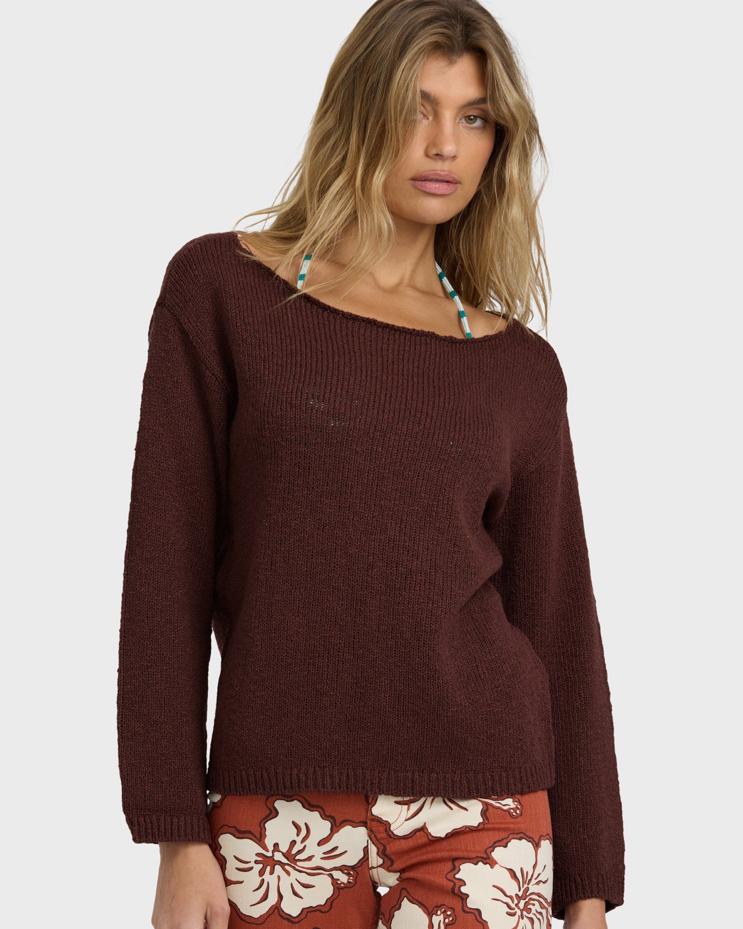 Teak ribbed sweater with wide neckline worn with patterned skirt.