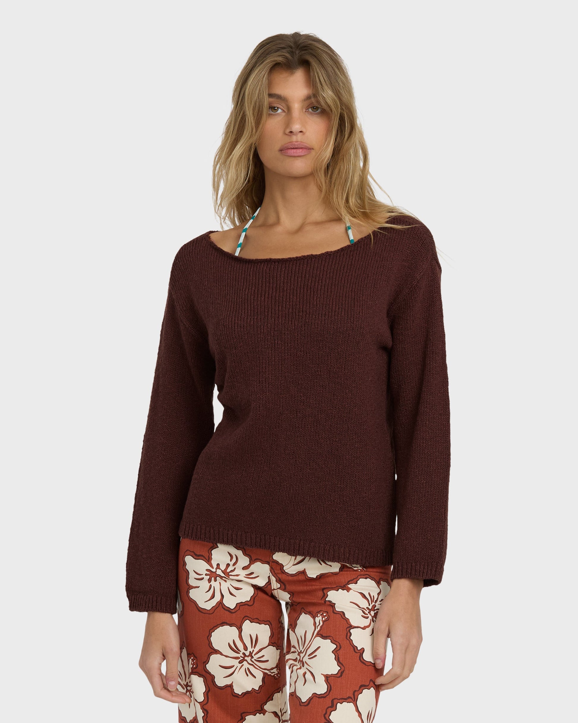 Teak ribbed sweater with crew neckline and long sleeves worn with floral patterned pants.