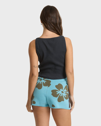 Light blue shorts with brown floral pattern, worn with black sleeveless ribbed top.