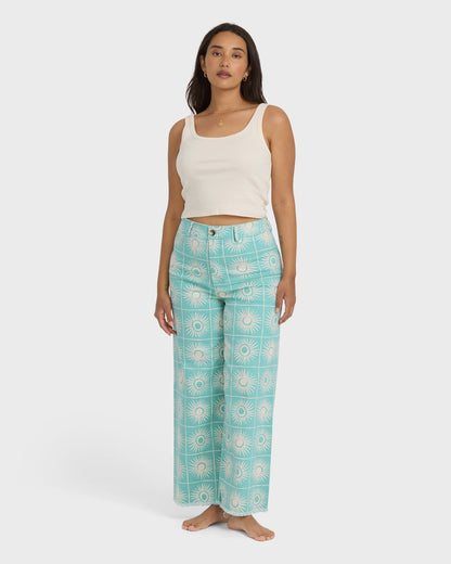 Misty blue twill pants with cream sunburst grid print, high-waisted with straight legs.