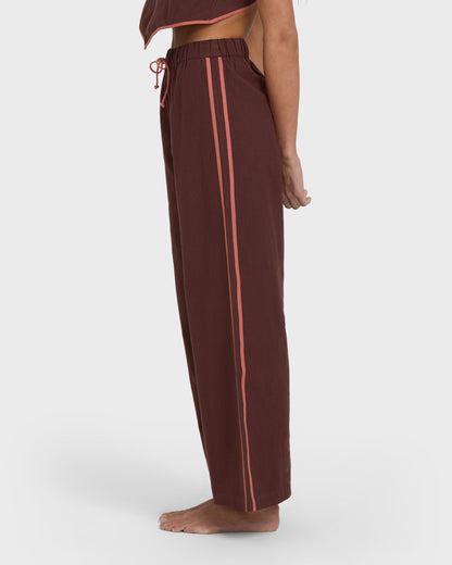 Teak elastic waist pants with coral side stripes and drawstring, shown on model from waist down.