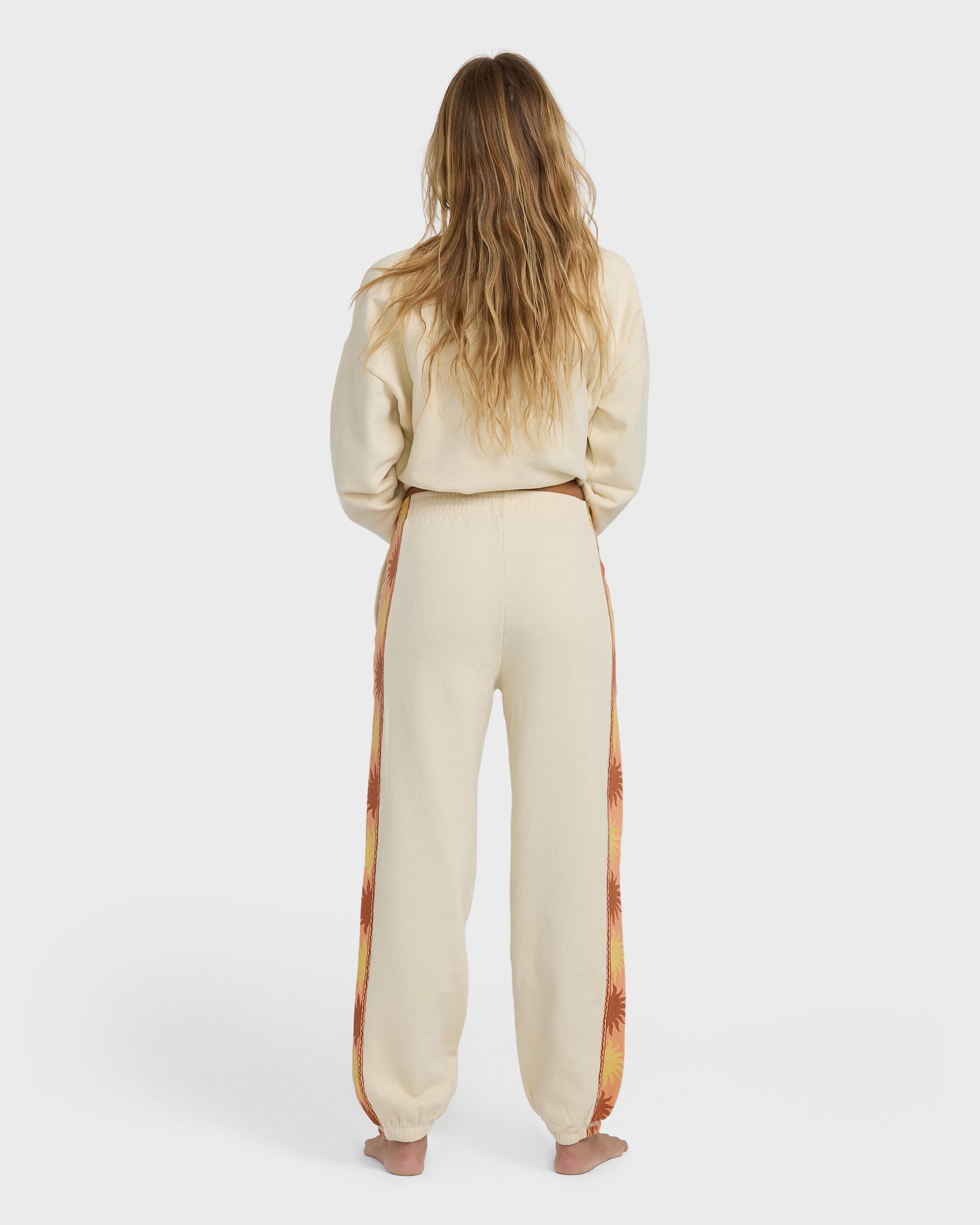 Cream joggers with floral patterned side stripe, shown from back on model wearing matching cream sweatshirt.