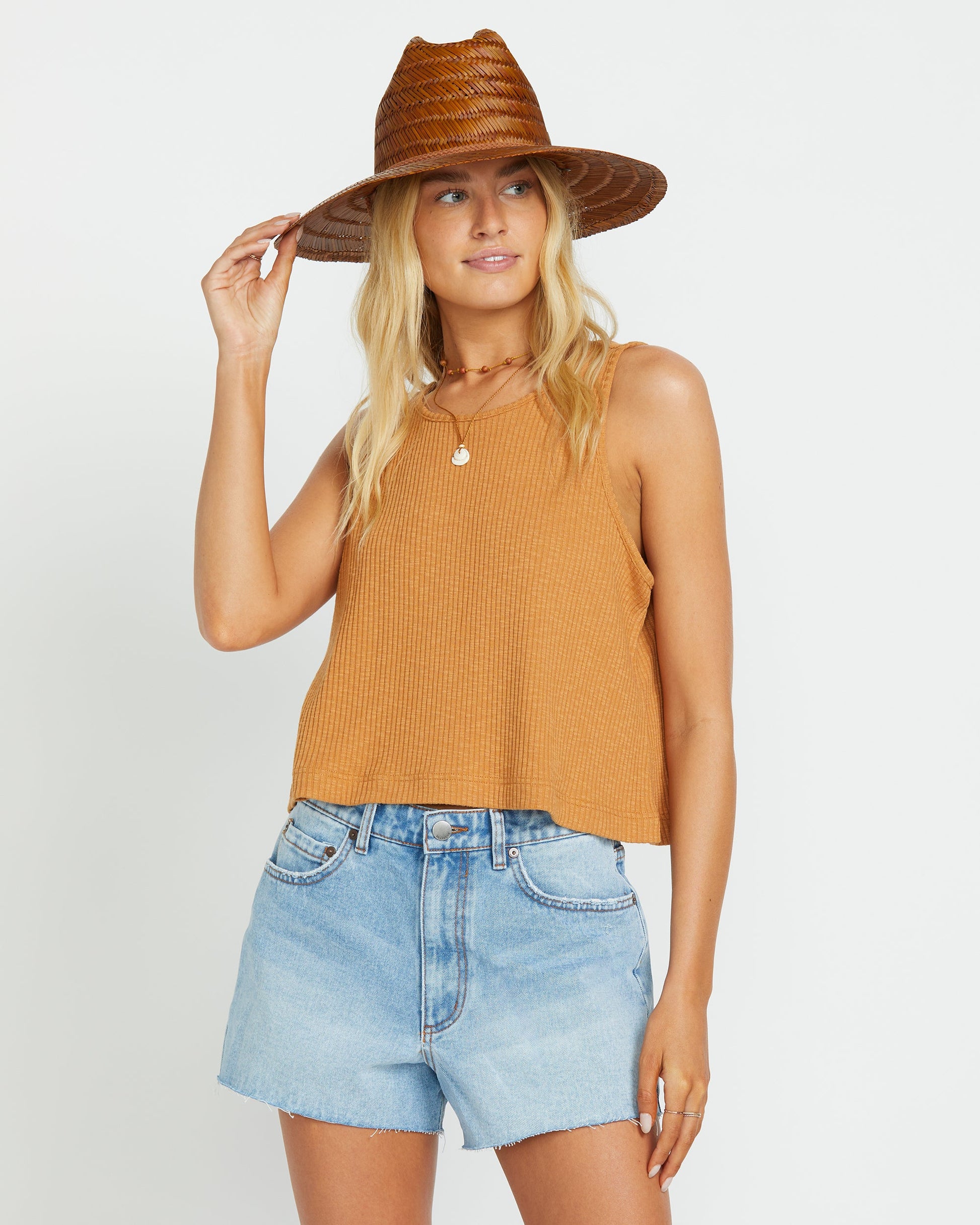 Light blue denim shorts with a frayed hem, paired with an orange ribbed tank top.