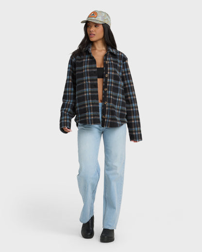 Black and blue plaid sherpa shacket with button front worn over black crop top and light blue jeans.