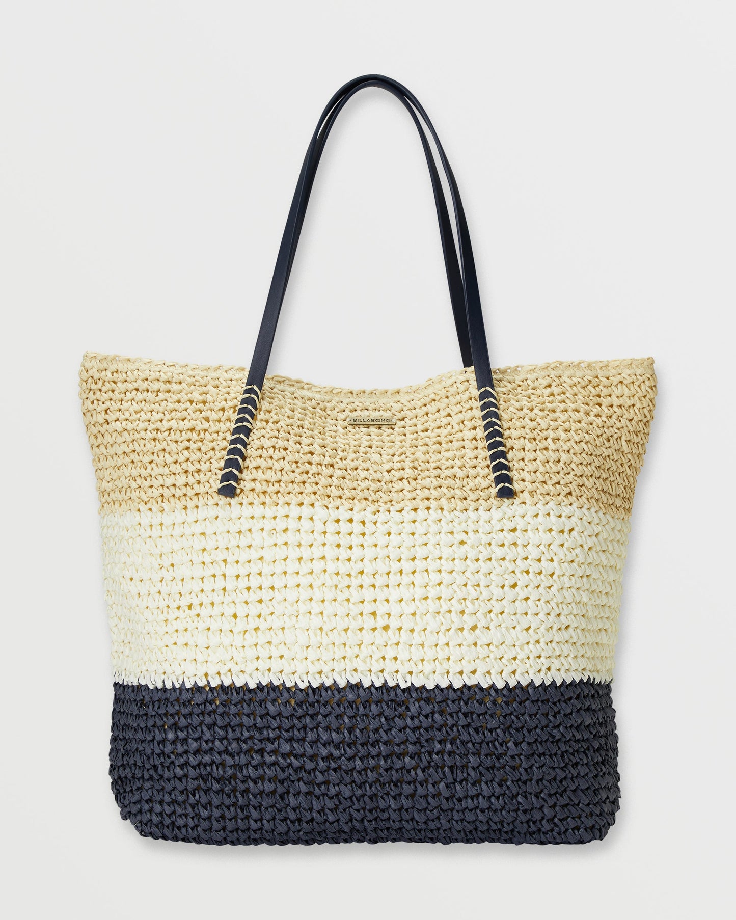 Black and cream woven straw tote bag with black handles and horizontal color blocking stripes.