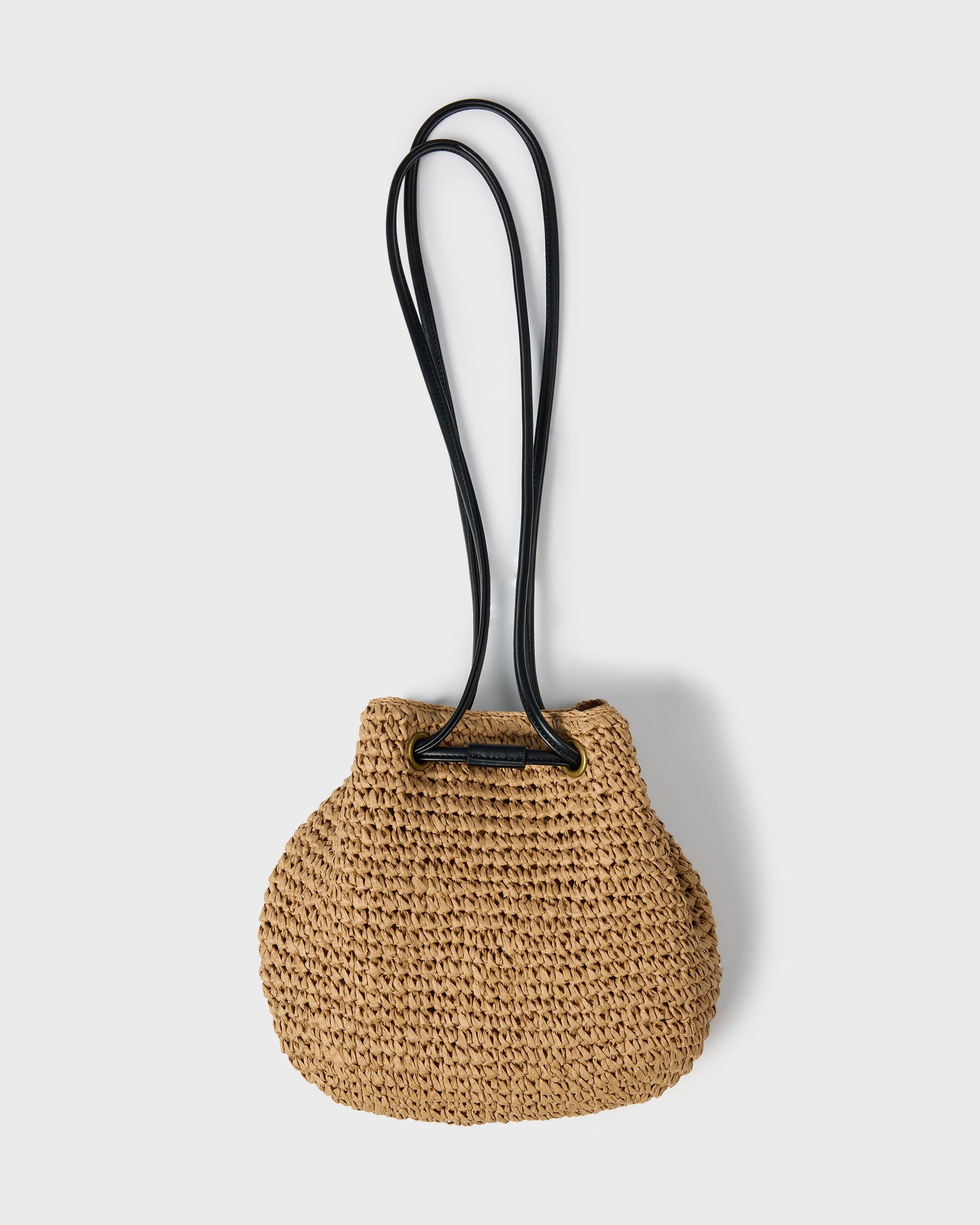 Tan woven straw mini tote bag with black crossbody straps.
