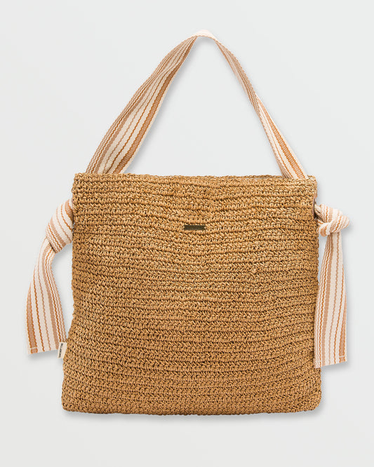 Tan woven straw tote bag with striped fabric handles and knotted side details.