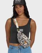 Black and white patterned waistbag with cream shoulder strap and gold hardware, worn across torso.
