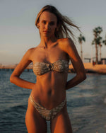 Green tea bandeau bikini top with geometric floral print and center bow detail.