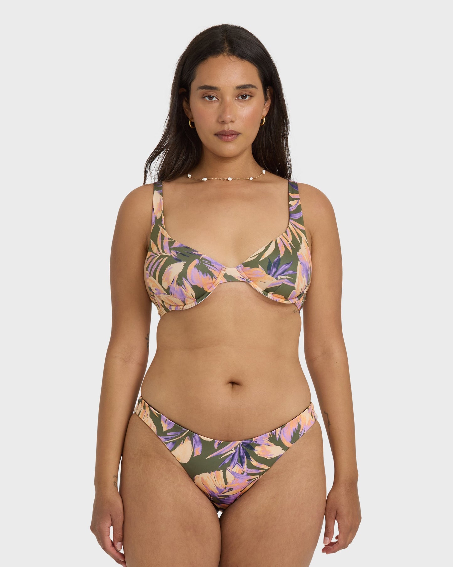 Tropical floral bikini bottom in purple, pink, and olive green with curved waistband and side ties.