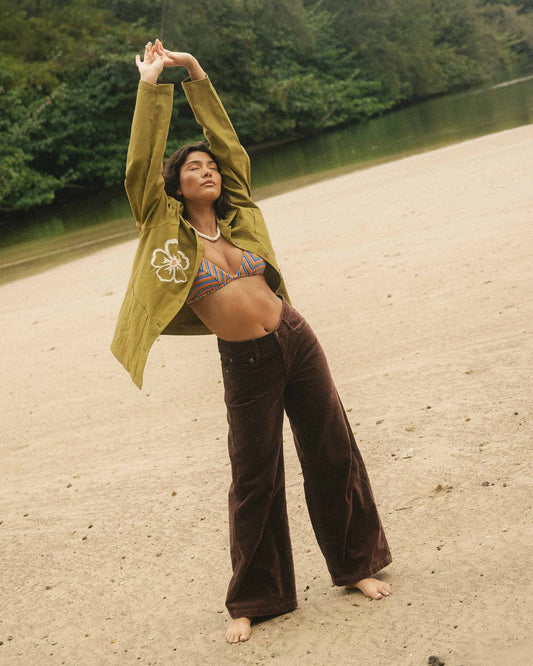 Brown corduroy pants with wide legs worn at ankle, shown on model outdoors.