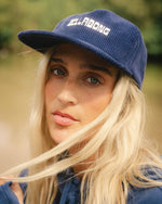 Celestial blue corduroy grandpa hat with white embroidered text on front and curved brim.