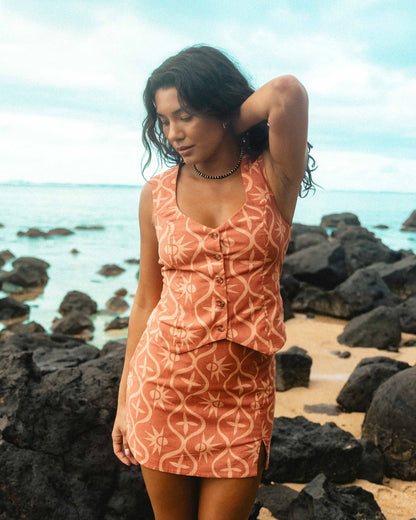 Dark coral sleeveless vest with geometric pattern and button front, worn over matching dress.