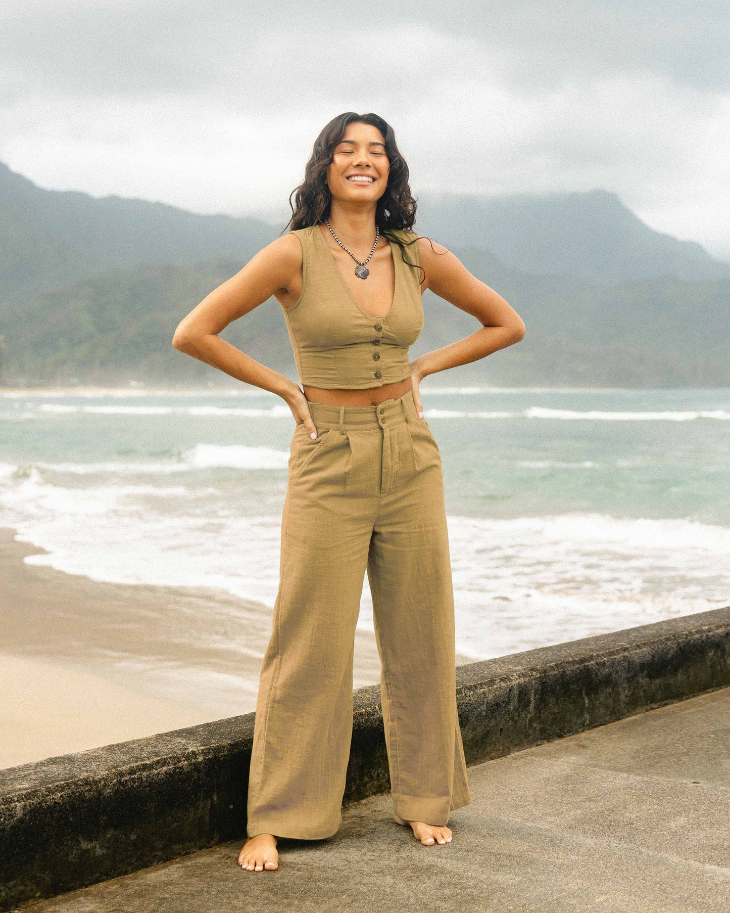 Tan sleeveless cropped vest with button front and matching high-waisted wide-leg pants.