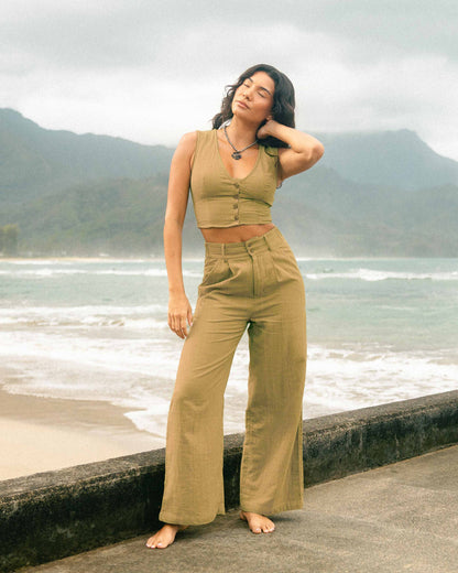 Mustard yellow tailor made pants with high waist and wide legs, worn with matching crop top.