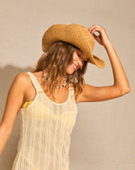 Natural woven straw cowboy hat with wide brim worn by a woman.