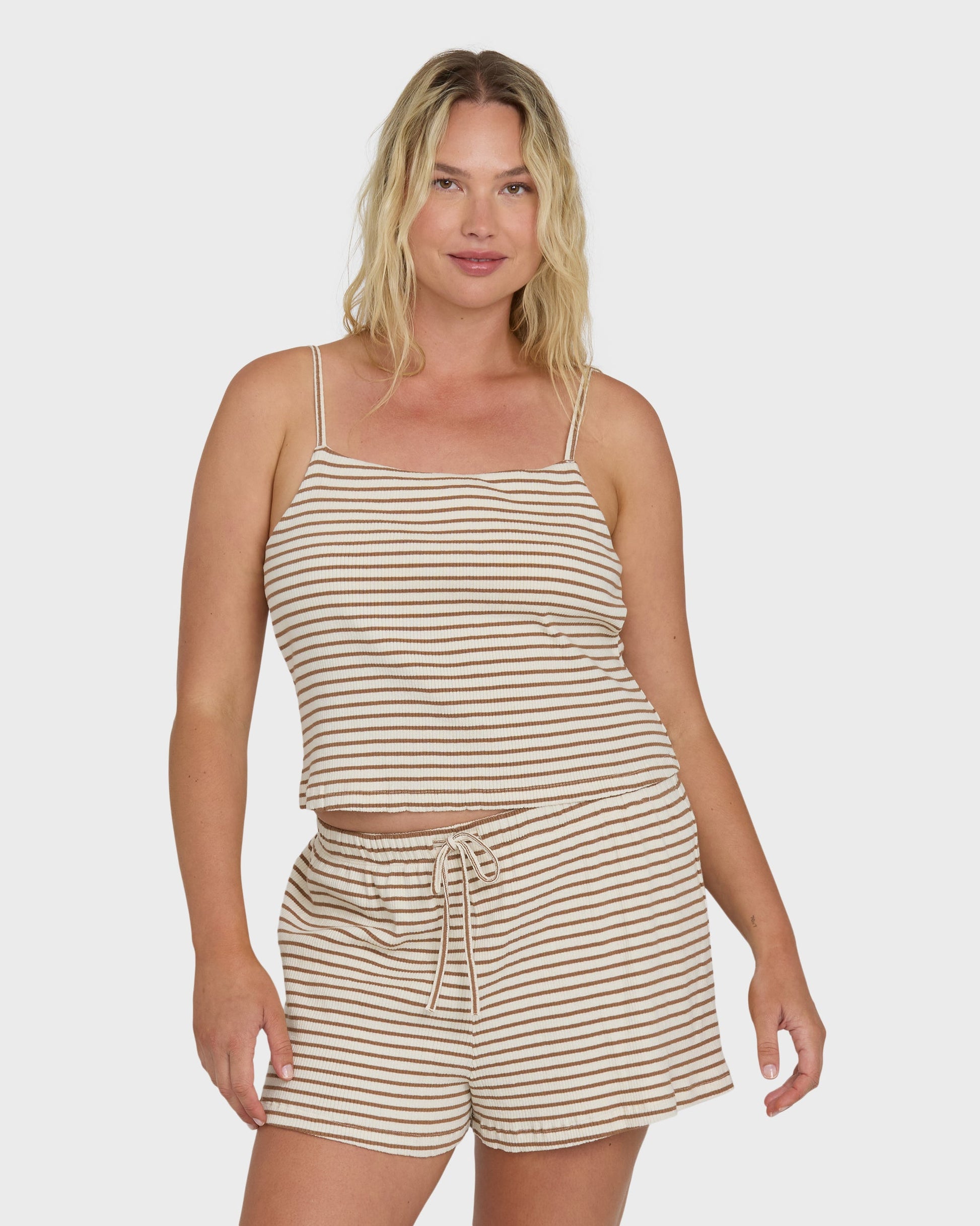 Brown and white striped sleeveless tank top with thin shoulder straps on a model.