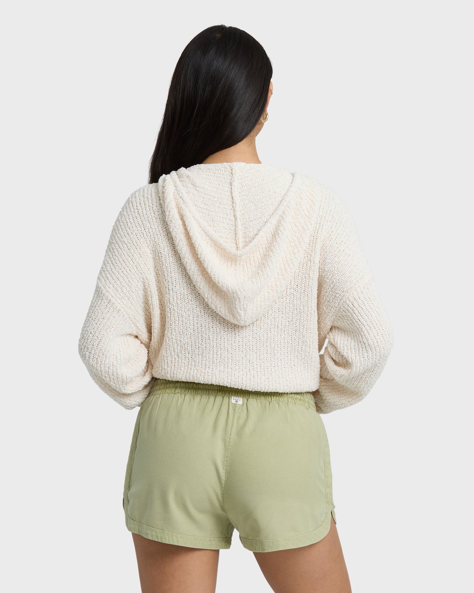 Avocado green shorts with elastic waist and side seams, shown from back view on model wearing cream hoodie.