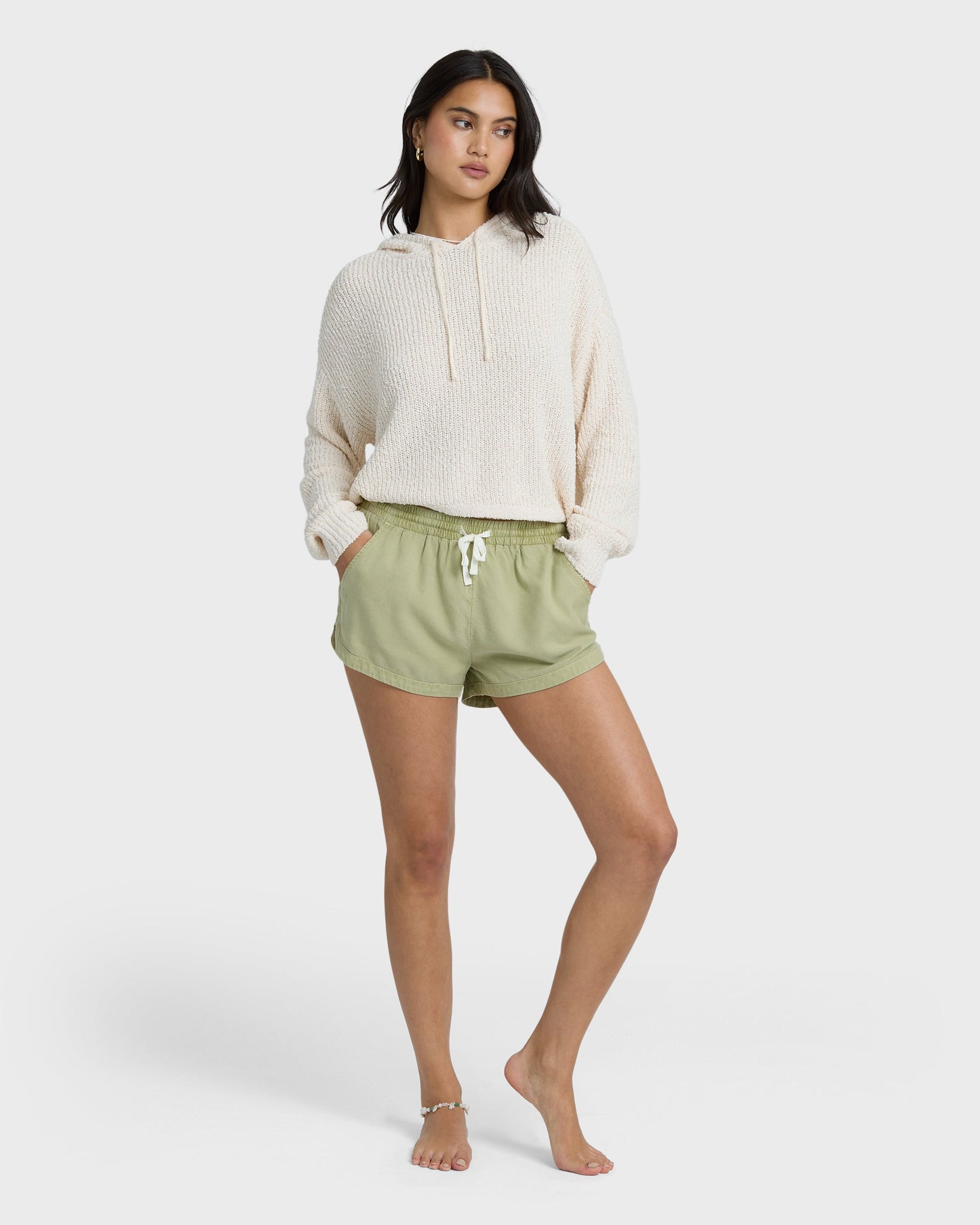 Avocado green shorts with elastic waist and drawstring, styled with cream hoodie.