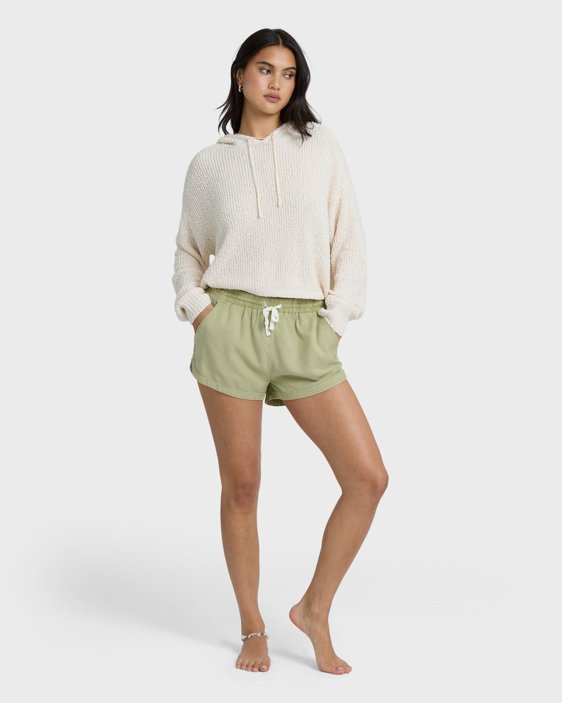 Avocado green shorts with elastic waist and drawstring, styled with cream hoodie.