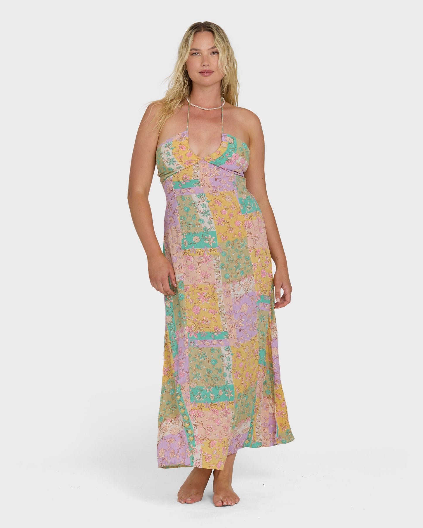 Sleeveless halter maxi dress in patchwork floral print with pink, yellow, green, and purple tones.