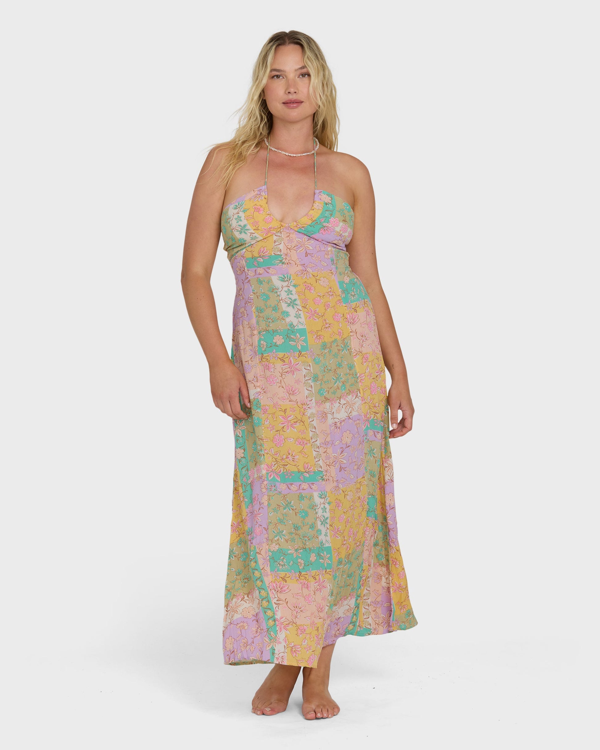 Sleeveless halter maxi dress in patchwork floral print with pink, yellow, green, and purple tones.