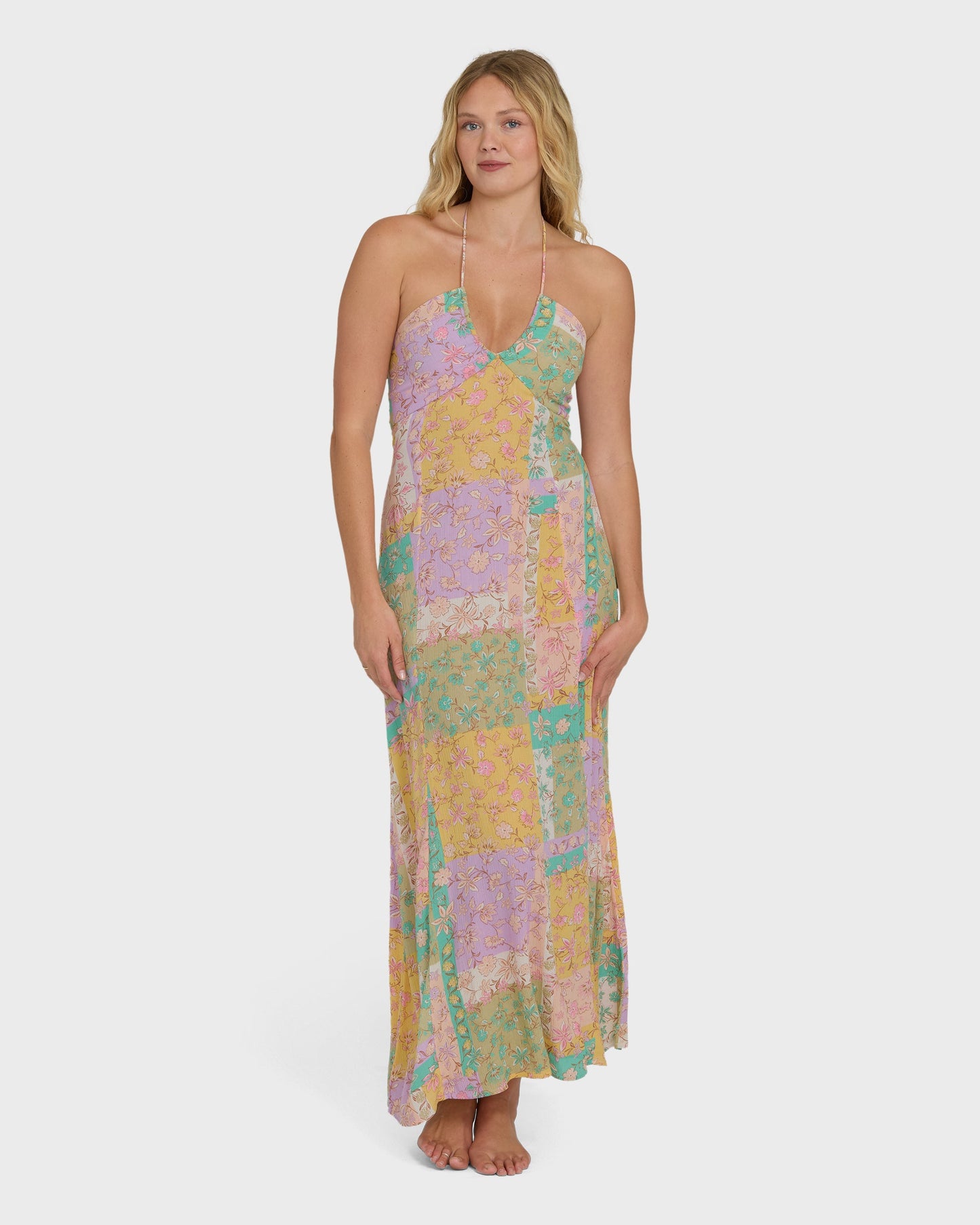 Halter maxi dress in violet, yellow, and green patchwork floral print with full-length skirt.