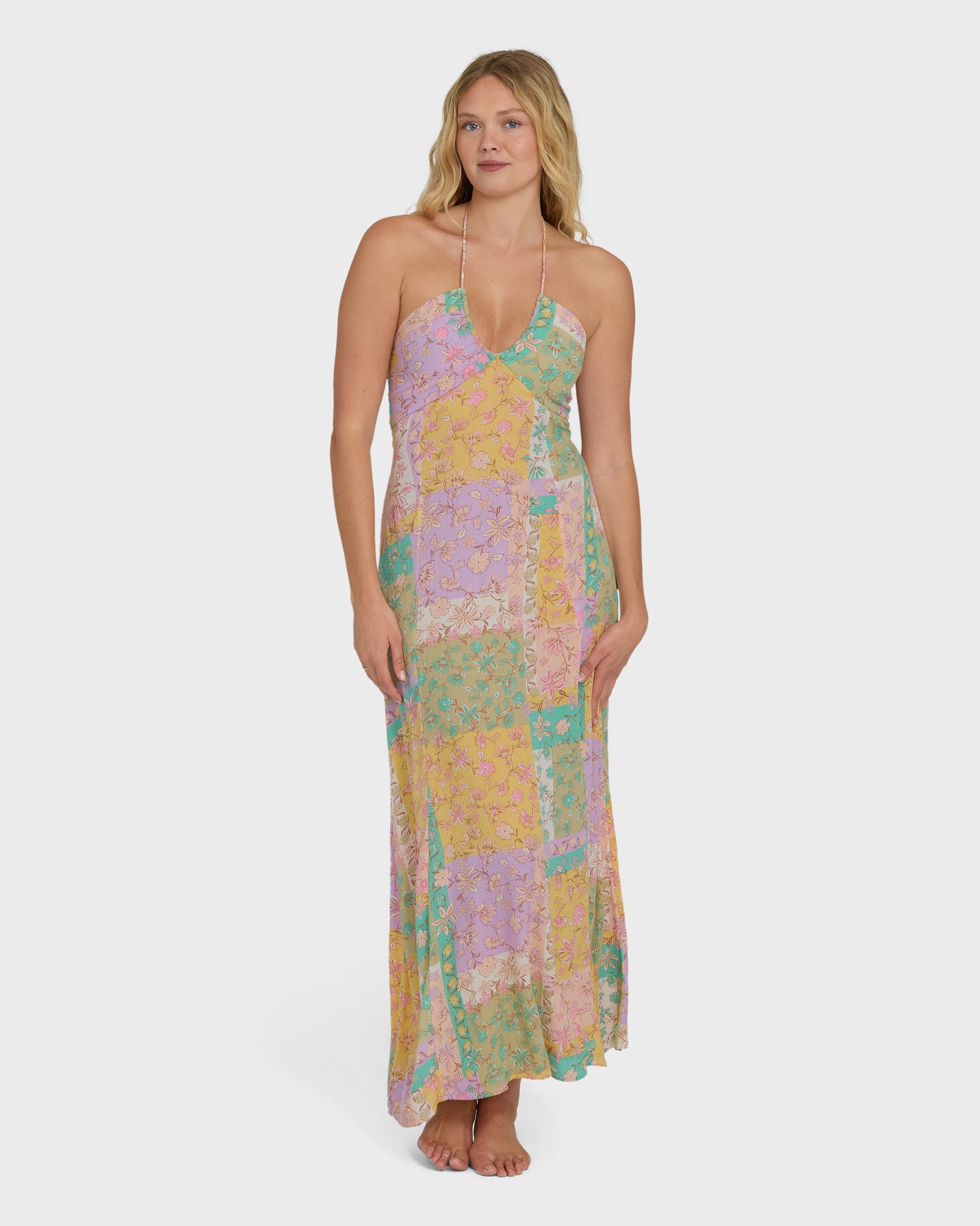 Halter maxi dress in violet, yellow, and green patchwork floral print with full-length skirt.
