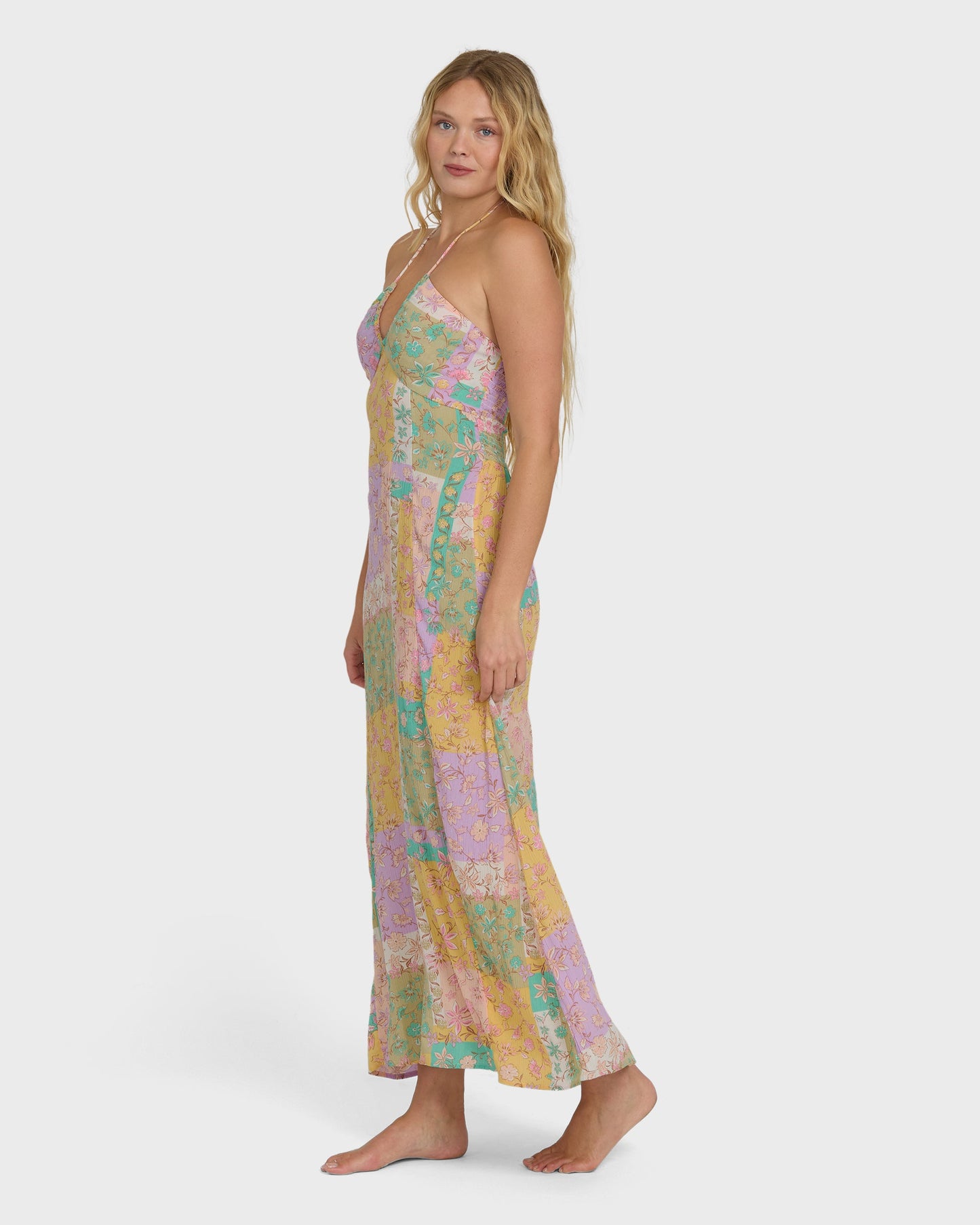 Violet maxi dress with multicolored floral patchwork pattern and halter neckline on model.