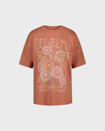 Brown t-shirt with floral design and 'Billabong' branding on a light gray background