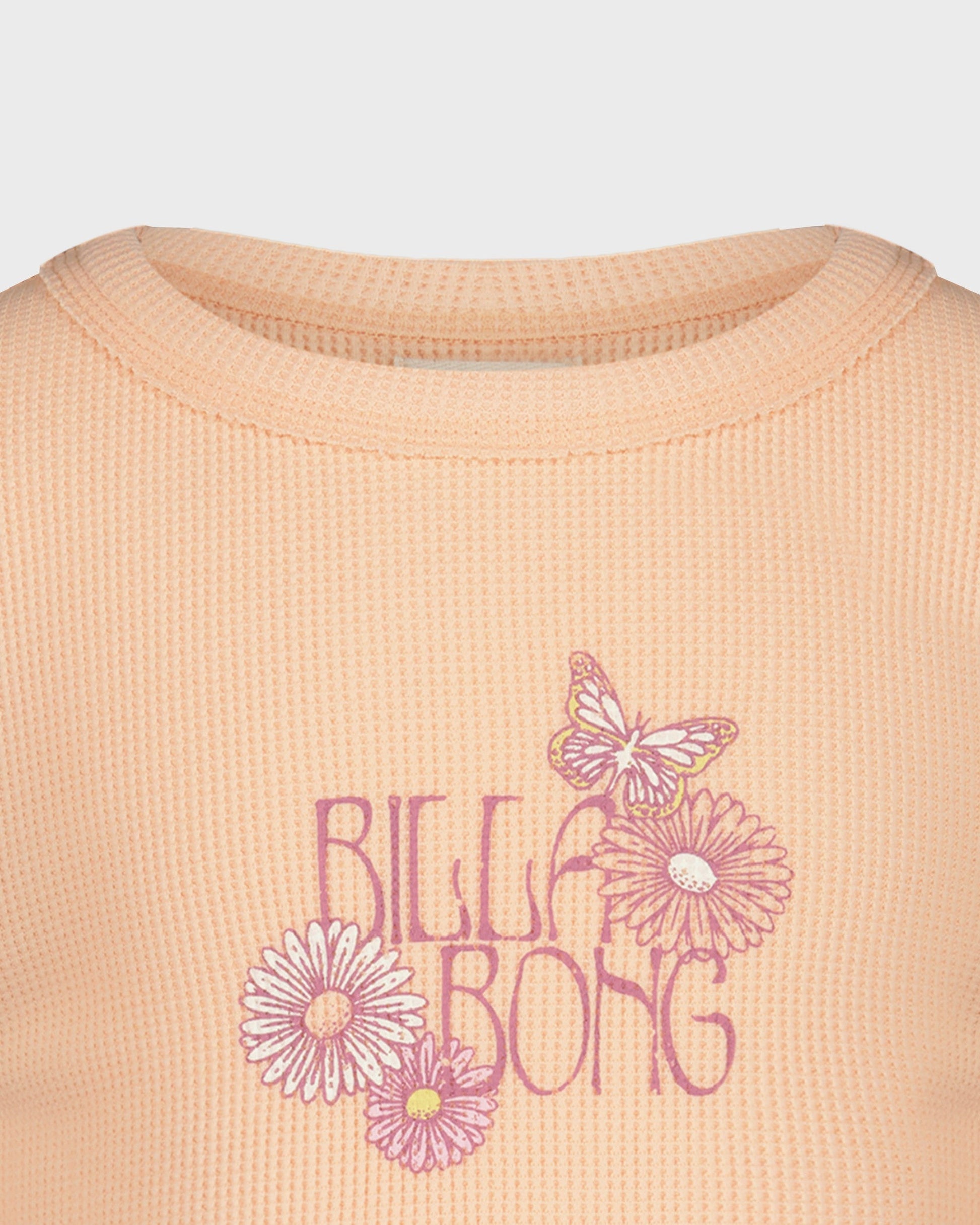 Close-up of a peach-colored shirt with floral designs and 'Billa Bong' text.