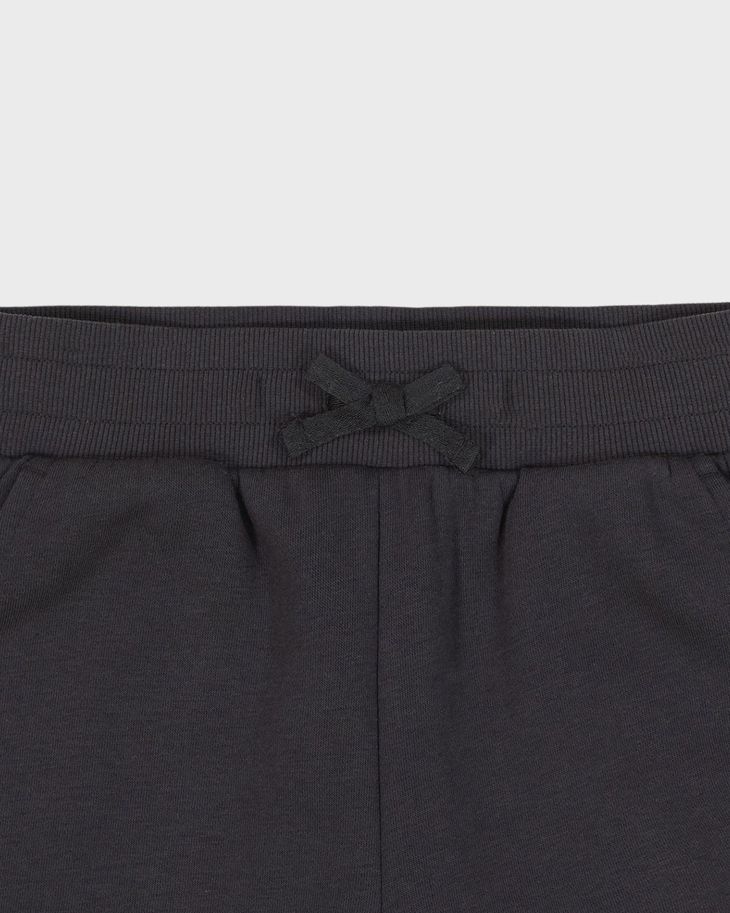 Dark gray sweatpants with a drawstring on a light gray background