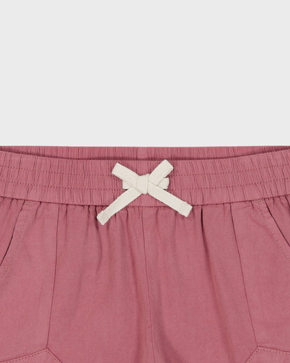 Pink shorts with a white drawstring on a light gray background