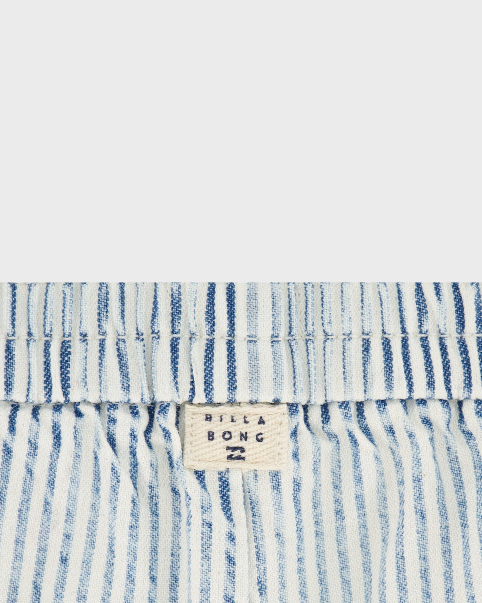 Close-up of blue and white striped fabric with a visible brand label.