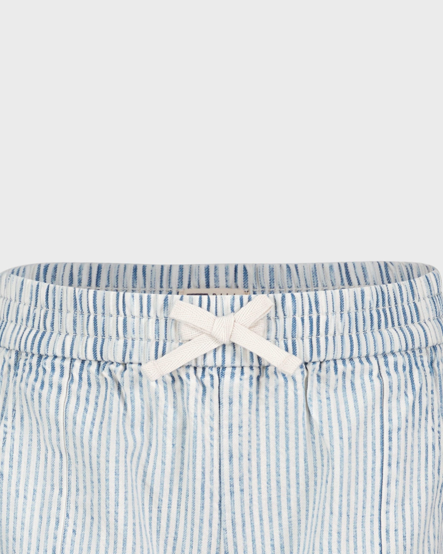 Blue and white striped shorts with a white bow on a light gray background
