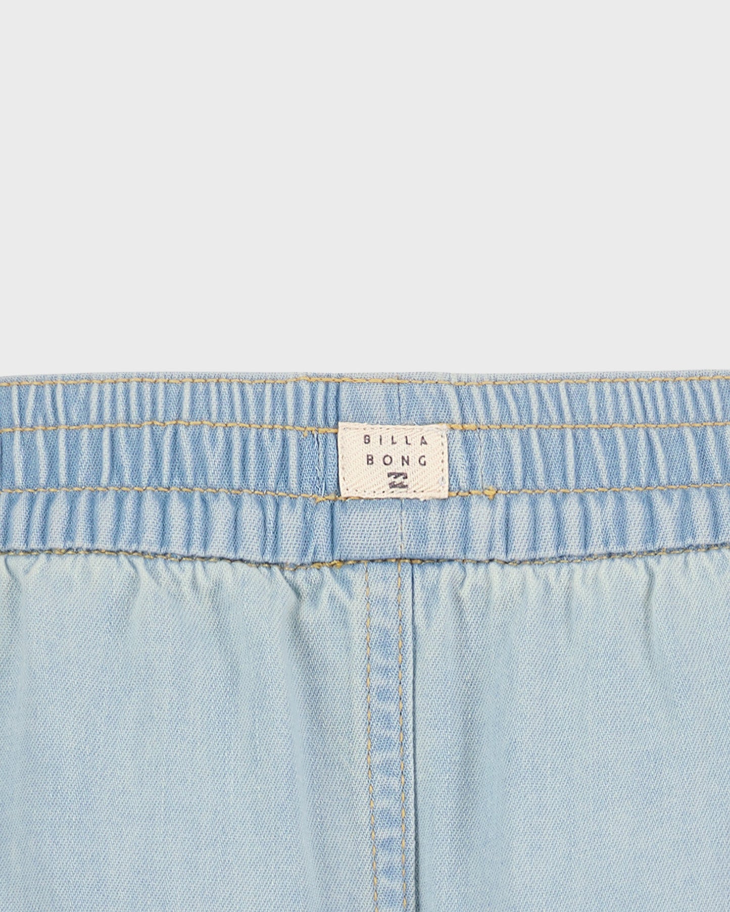 Close-up of light blue denim fabric with a Billabong label.