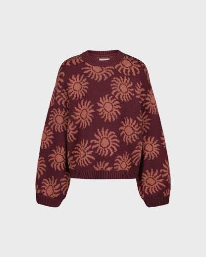 Maroon sweater with sun pattern on a light gray background