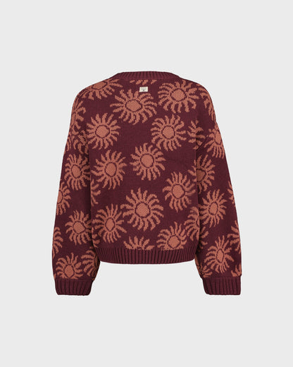 Maroon sweater with sun pattern on a light gray background