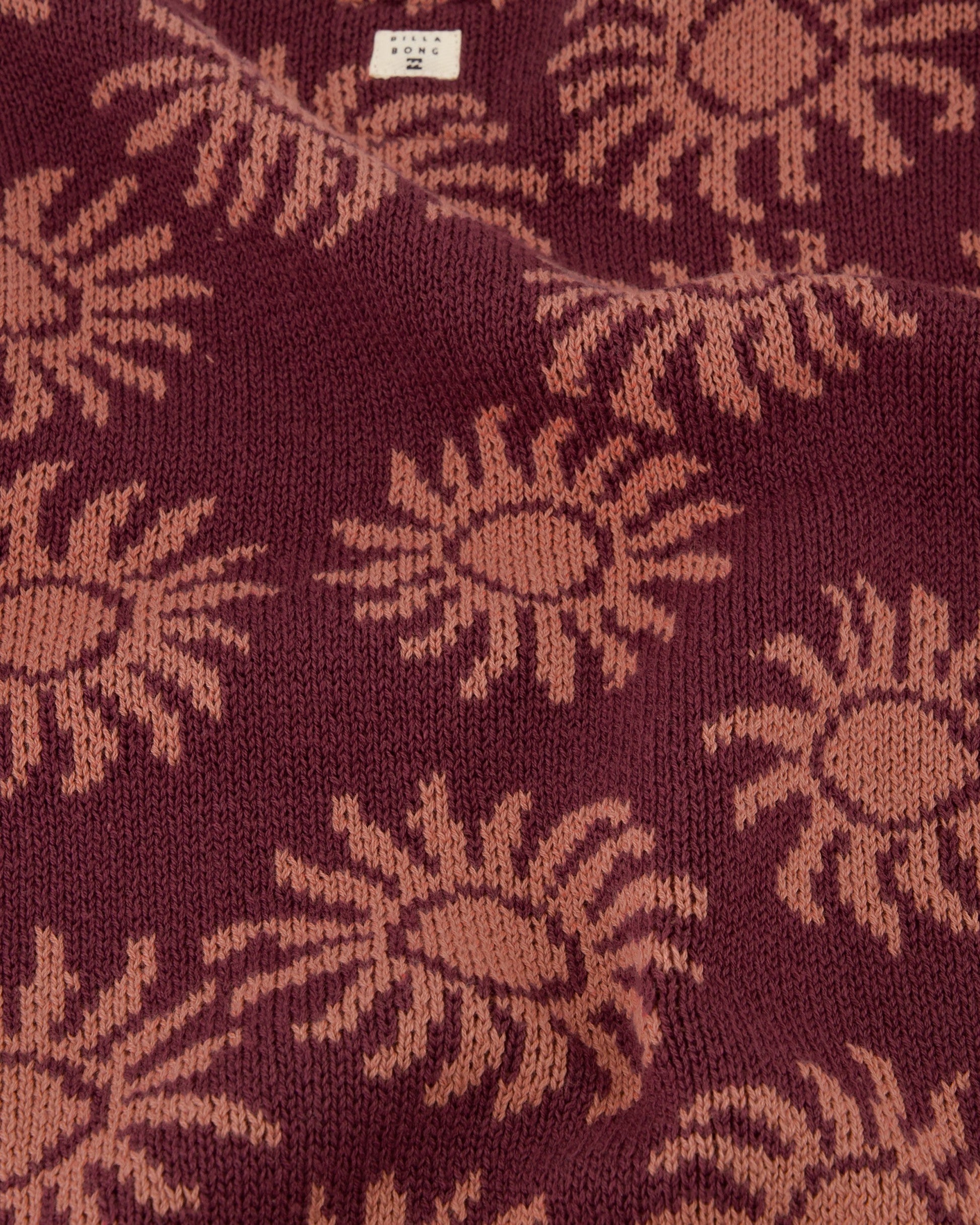 Close-up of a fabric with sunflower pattern on a maroon background