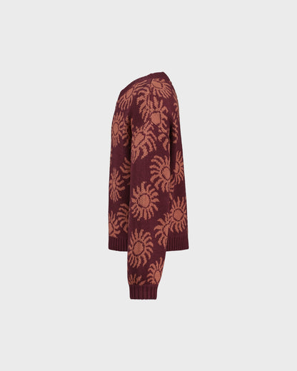 Maroon cardigan with sun pattern on a light gray background