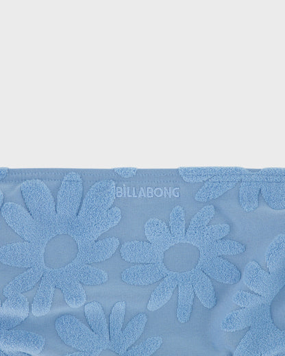 Blue towel with floral patterns and 'Billabong' branding on a light gray background