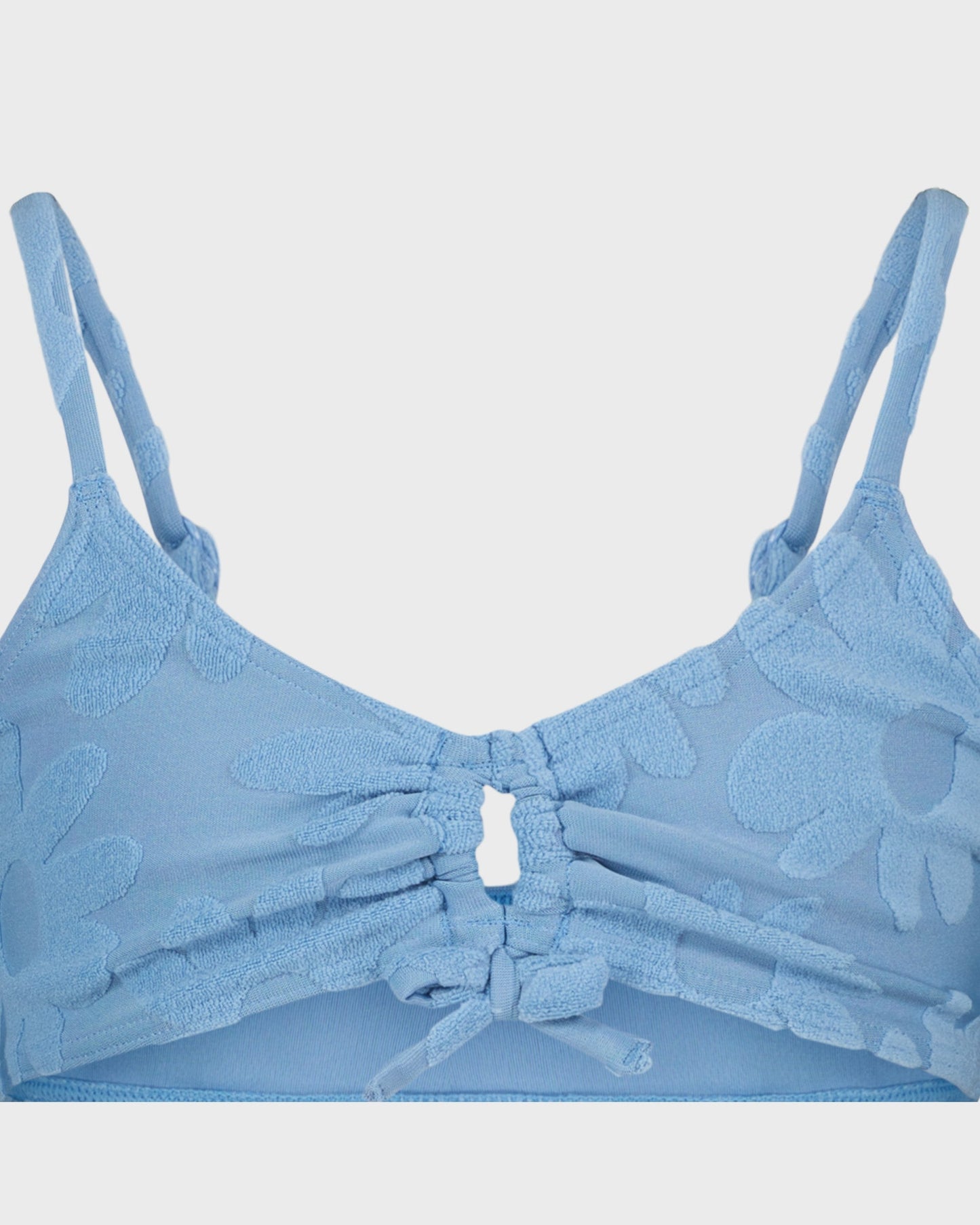 Blue bra with floral patterns on a light gray background