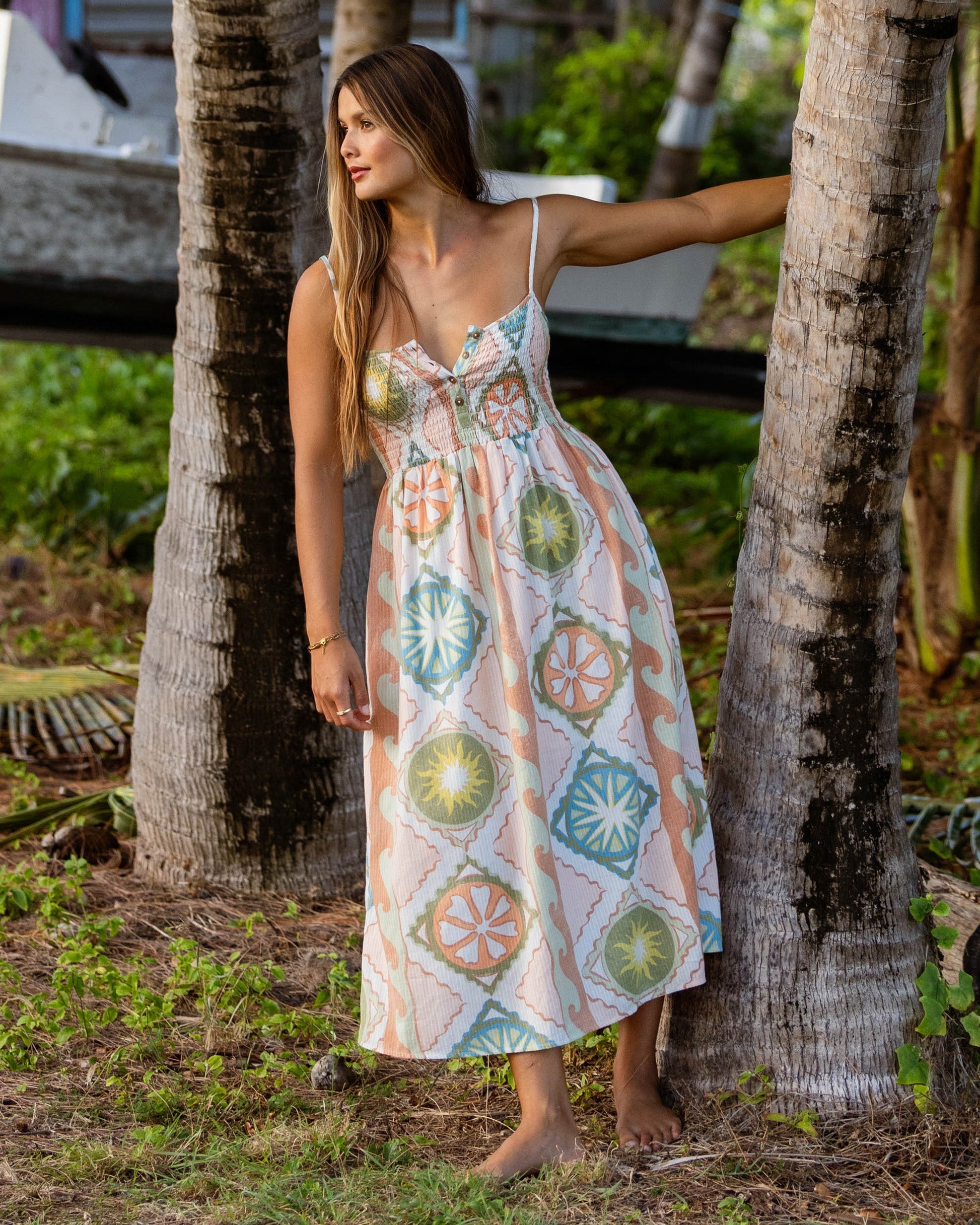 White midi dress with colorful geometric medallion print, spaghetti straps, and V-neckline.