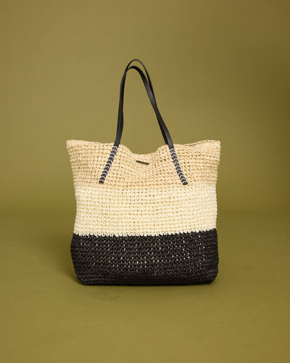 Woven tote bag with natural straw upper half, black woven lower half, and black rope handles.